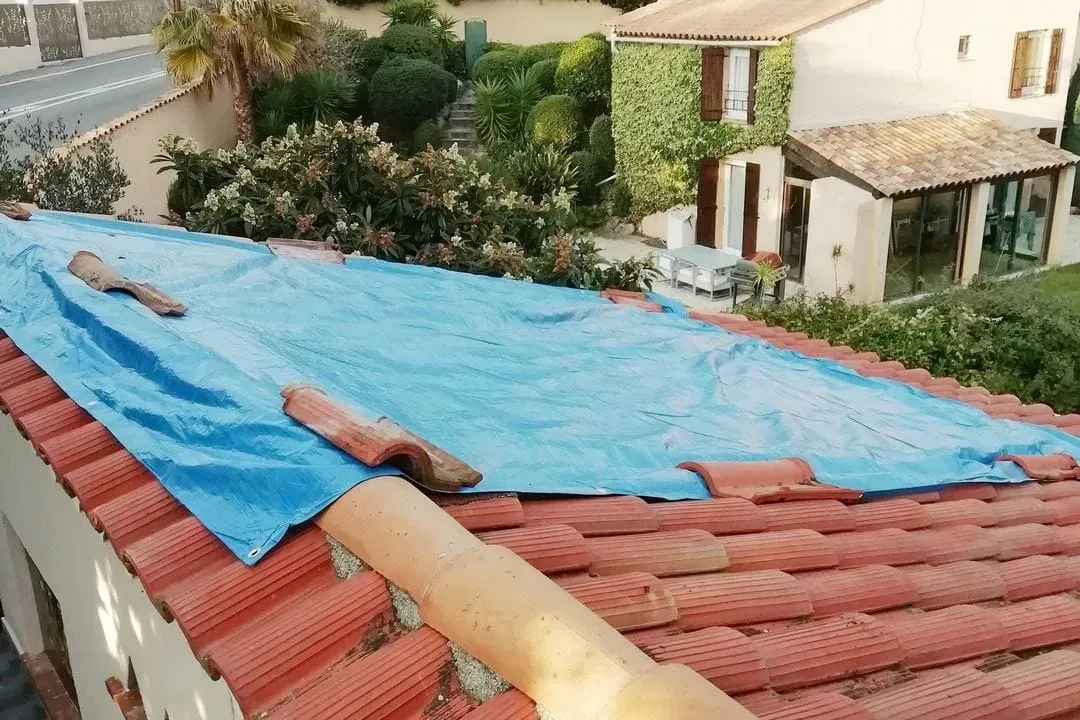 Bâche posée sur une toiture en tuiles canal